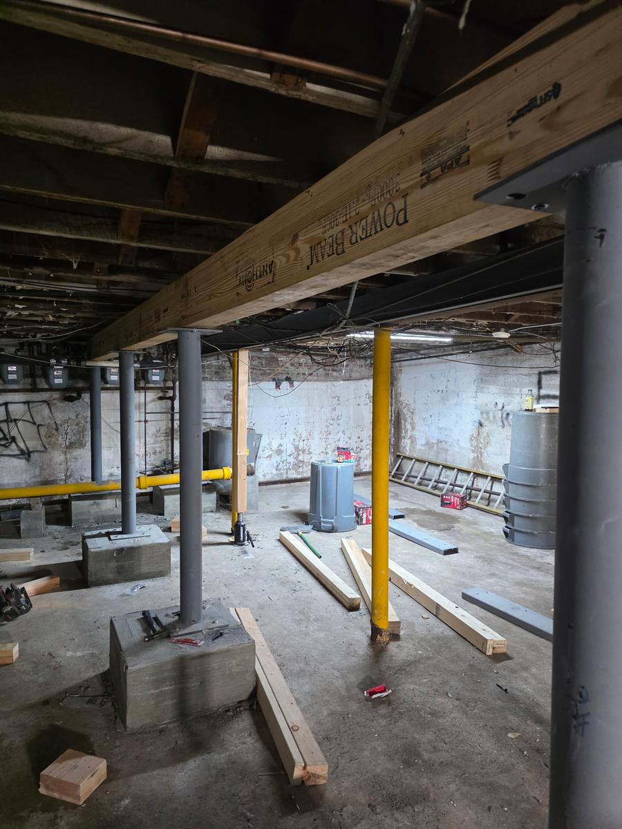 New engineered wood beam supported by steel columns in a basement