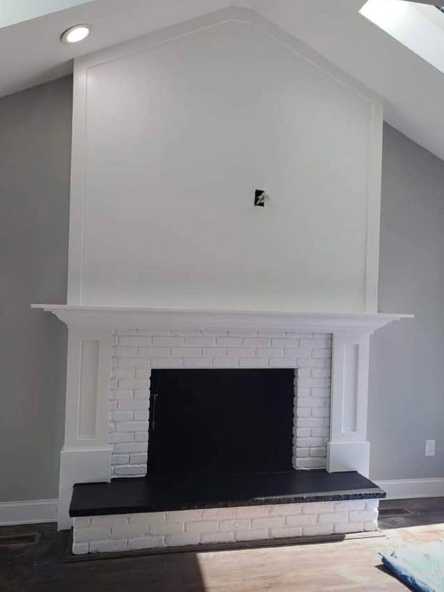 After: white-painted brick fireplace with custom mantel, trimmed surround, and paneled chimney breast
