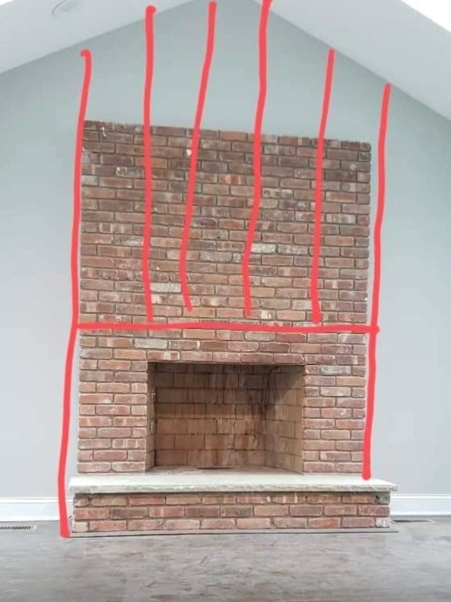 Before: bare red brick fireplace marked up with the planned layout