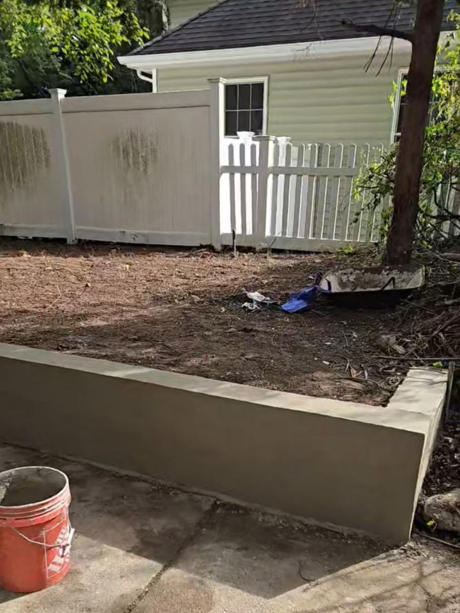 After: clean new retaining wall along a leveled yard